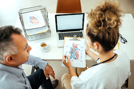 Patient and the Doctor Look at the Results of the Heart