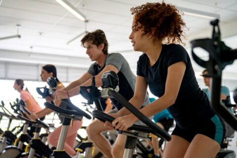 A woman during a spin class to improve her cardiovascular health